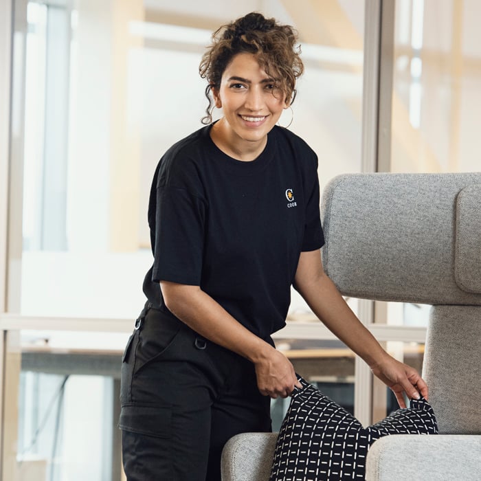  Woman putting a pillow on a chair and smiling |Coor 